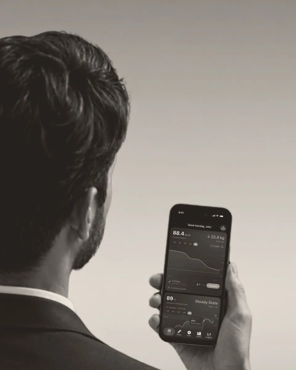 A man in a suit checks his progress in Althea on his iPhone